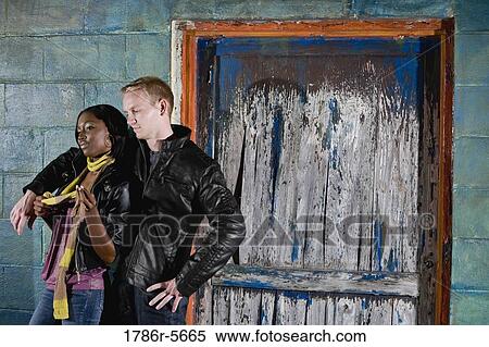 Stock Photography - Interracial couple standing by grungy doorway. Fotosearch