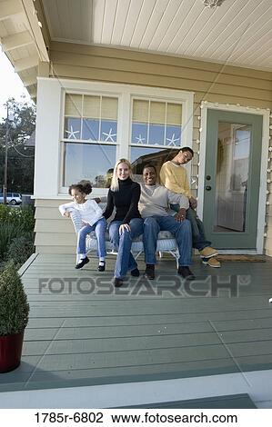 Interracial family sitting together on porch View Large Photo Image Stock Image - Interracial family sitting together on porch. Fotosearch
