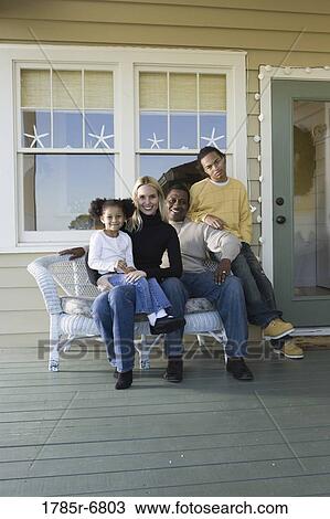 Interracial family sitting together on porch View Large Photo Image Stock Image - Interracial family sitting together on porch. Fotosearch