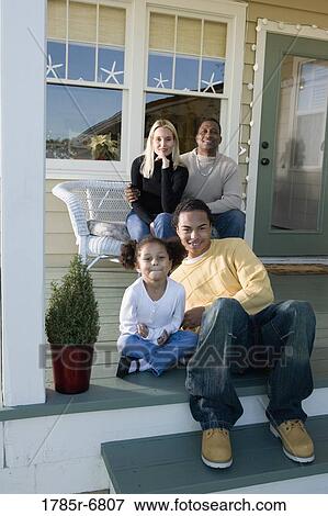 Interracial family sitting together on porch View Large Photo Image Stock Photo - Interracial family sitting together on porch. Fotosearch