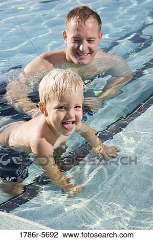 Little boy and father playing in swimming pool View Large Photo Image Stock Image - Little boy and father playing in swimming pool. Fotosearch