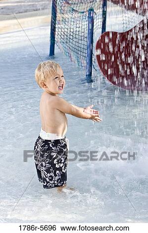 Little boy playing in splashing water View Large Photo Image Stock Photograph - Little boy playing in splashing water. Fotosearch