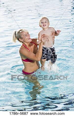 Stock Photo - Little boy with mother in swimming pool. Fotosearch