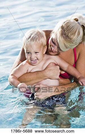 Stock Photo - Little boy with mother in swimming pool. Fotosearch