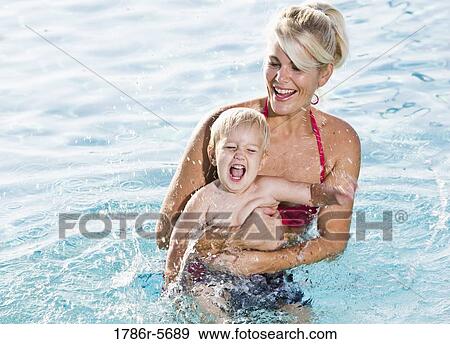 Stock Photo - Little boy with mother in swimming pool. Fotosearch