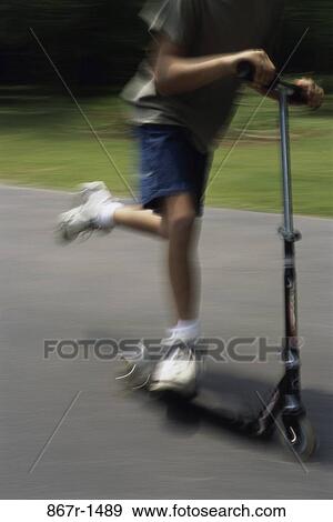 Low section view of a boy on a scooter View Large Photo Image Stock Photo - Low section view of a boy on a scooter. Fotosearch