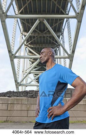 Male Athlete standing beneath bridge View Large Photo Image Picture - Male Athlete standing beneath bridge. Fotosearch