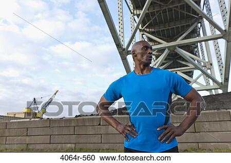 Male Athlete standing beneath bridge View Large Photo Image Stock Image - Male Athlete standing beneath bridge. Fotosearch