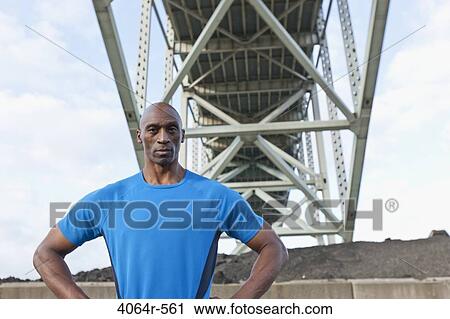 Male Athlete standing beneath bridge View Large Photo Image Stock Image - Male Athlete standing beneath bridge. Fotosearch