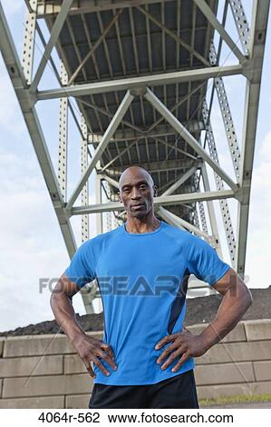 Male Athlete standing beneath bridge View Large Photo Image Stock Image - Male Athlete standing beneath bridge. Fotosearch