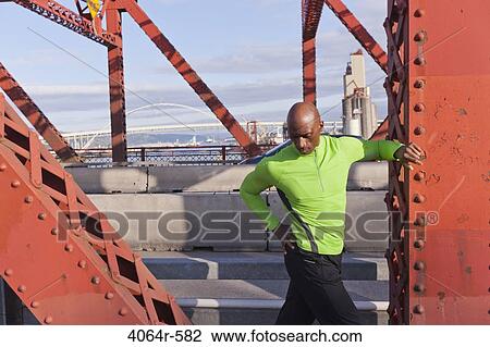 Male jogger, stretching on bridge View Large Photo Image Stock Image - Male jogger, stretching on bridge. Fotosearch