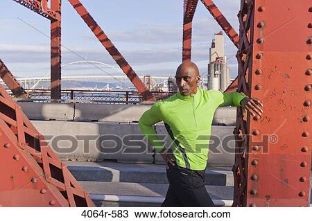 Male jogger, stretching on bridge View Large Photo Image Stock Image - Male jogger, stretching on bridge. Fotosearch