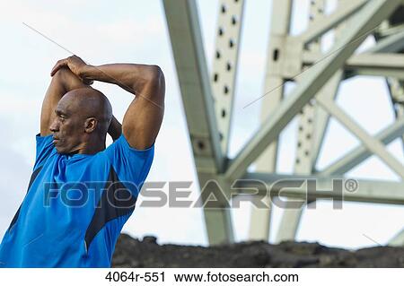 Male urban athlete stretching View Large Photo Image Stock Image - Male urban athlete stretching. Fotosearch