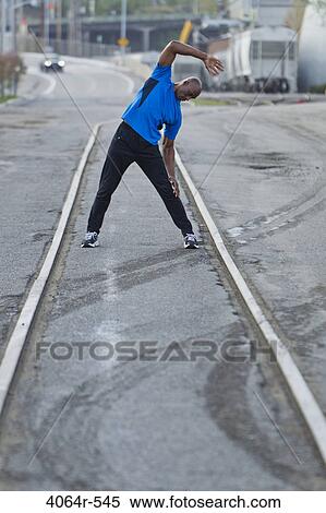 Stock Photography - Male urban athlete stretching. Fotosearch