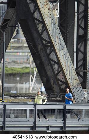 Man and woman running on bridge View Large Photo Image Stock Photo - Man and woman running on bridge. Fotosearch