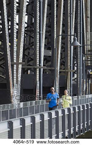 Man and woman running on bridge View Large Photo Image Stock Photo - Man and woman running on bridge. Fotosearch