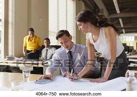 Man and woman talking over plans at desk in office View Large Photo Image Stock Image - Man and woman talking over plans at desk in office. Fotosearch