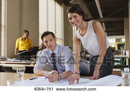 Man and woman talking over plans at desk in office, portrait View Large Photo Image Stock Image - Man and woman talking over plans at desk in office, portrait. Fotosearch