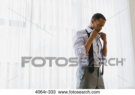 Stock Image - Man getting dressed. Fotosearch
