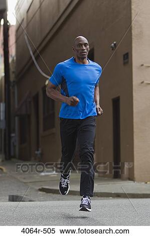 Stock Photography - Man jogging in street. Fotosearch