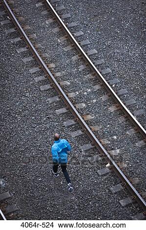 Man running across railroad tracks View Large Photo Image Picture - Man running across railroad tracks. Fotosearch