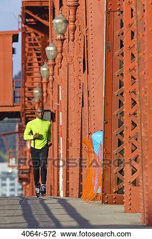 Man running along bridge View Large Photo Image Stock Image - Man running along bridge. Fotosearch