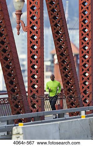 Stock Photo - Man running along bridge. Fotosearch