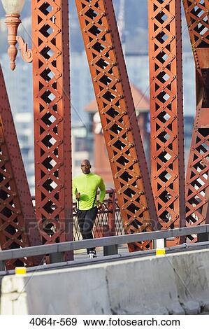 Man running along bridge View Large Photo Image Stock Photo - Man running along bridge. Fotosearch