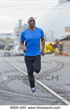 Man running in industrial area of city View Large Photo Image Picture - Man running in industrial area of city. Fotosearch