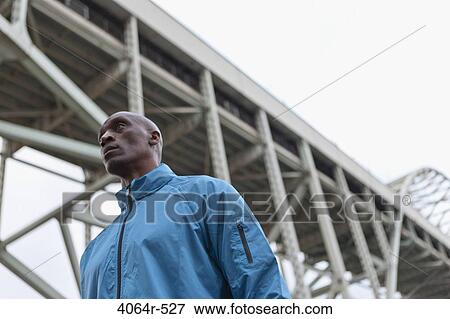 Man standing beneath bridge View Large Photo Image Stock Photo - Man standing beneath bridge. Fotosearch