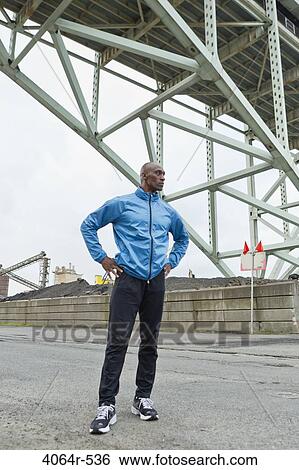 Man standing beneath bridge View Large Photo Image Stock Photograph - Man standing beneath bridge. Fotosearch