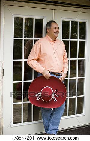 Stock Image - Mature man holding a sombrero. Fotosearch