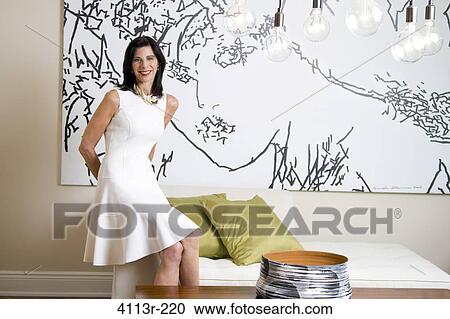Mature woman sitting on sofa in art gallery View Large Photo Image Stock Image - Mature woman sitting on sofa in art gallery. Fotosearch
