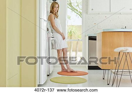 Mature woman standing in the kitchen View Large Photo Image Stock Photo - Mature woman standing in the kitchen. Fotosearch