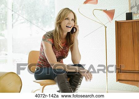 Mature woman talking on a mobile phone and smiling View Large Photo Image Stock Image - Mature woman talking on a mobile phone and smiling. Fotosearch