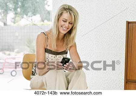 Mature woman text messaging and smiling View Large Photo Image Stock Image - Mature woman text messaging and smiling. Fotosearch