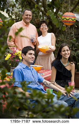 Stock Photo - Mexican-American family at a picnic table the backyard. Fotosearch