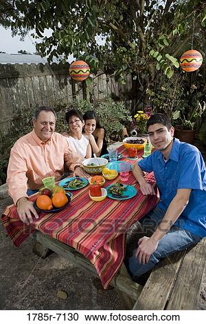 Stock Image - Mexican-American family enjoying a picnic in the backyard. Fotosearch