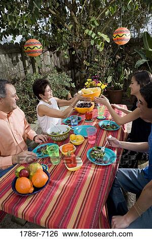 Stock Photograph - Mexican-American family enjoying a picnic in the backyard. Fotosearch