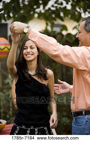 Picture - Mexican-American man dancing with his daughter. Fotosearch