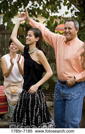 Mexican-American man dancing with his daughter while his wife claps in the background View Large Photo Image Stock Photography - Mexican-American man dancing with his daughter while his wife claps in the background. Fotosearch