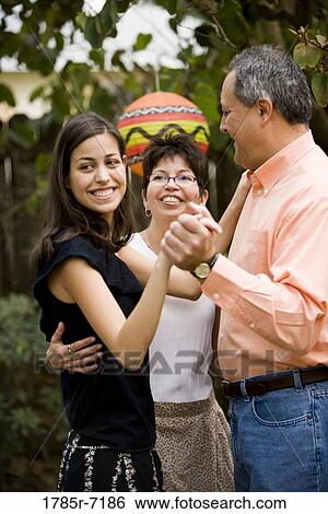 Mexican-American man dancing with daughter while his wife hugs them both View Large Photo Image Stock Photograph - Mexican-American man dancing with daughter while his wife hugs them both. Fotosearch