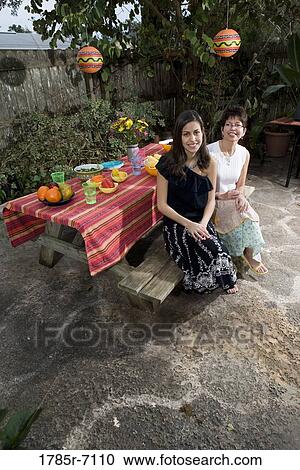 Mexican-American mother and daughter sitting at a picnic table View Large Photo Image Stock Image - Mexican-American mother and daughter sitting at a picnic table. Fotosearch