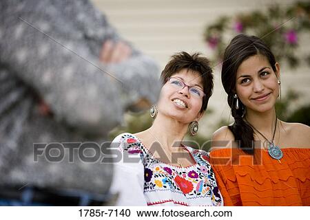 Stock Image - Mexican mother and daughter sitting together. Fotosearch