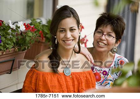 Mexican mother and daughter sitting together on front porch of house View Large Photo Image Stock Image - Mexican mother and daughter sitting together on front porch of house. Fotosearch