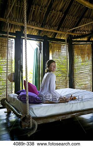 Mexico, Quintana Roo, Tulum, Woman sitting on hanging bed in hut View Large Photo Image Stock Photo - Mexico, Quintana Roo, Tulum, Woman sitting on hanging bed in hut. Fotosearch