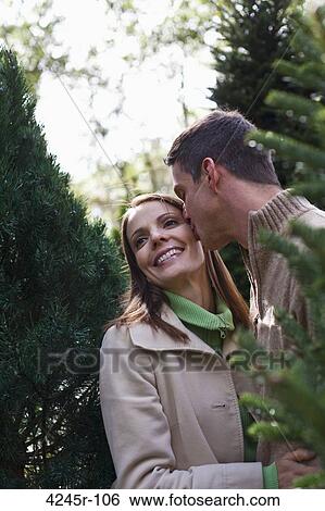 Mid adult man kissing his wife View Large Photo Image Stock Photograph - Mid adult man kissing his wife. Fotosearch