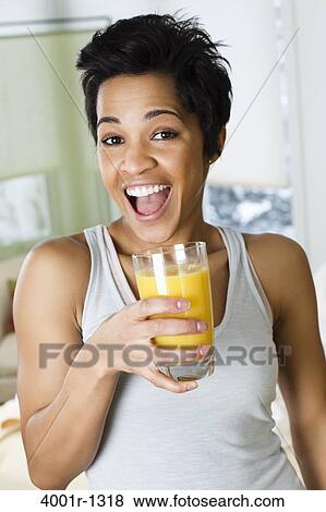 Mid adult woman holding a glass of orange juice View Large Photo Image Stock Photo - Mid adult woman holding a glass of orange juice. Fotosearch