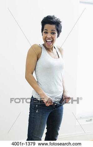 Mid adult woman holding out waistband of jeans View Large Photo Image Stock Photo - Mid adult woman holding out waistband of jeans. Fotosearch