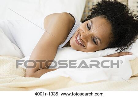 Mid adult woman lying on the bed and smiling View Large Photo Image Stock Photography - Mid adult woman lying on the bed and smiling. Fotosearch